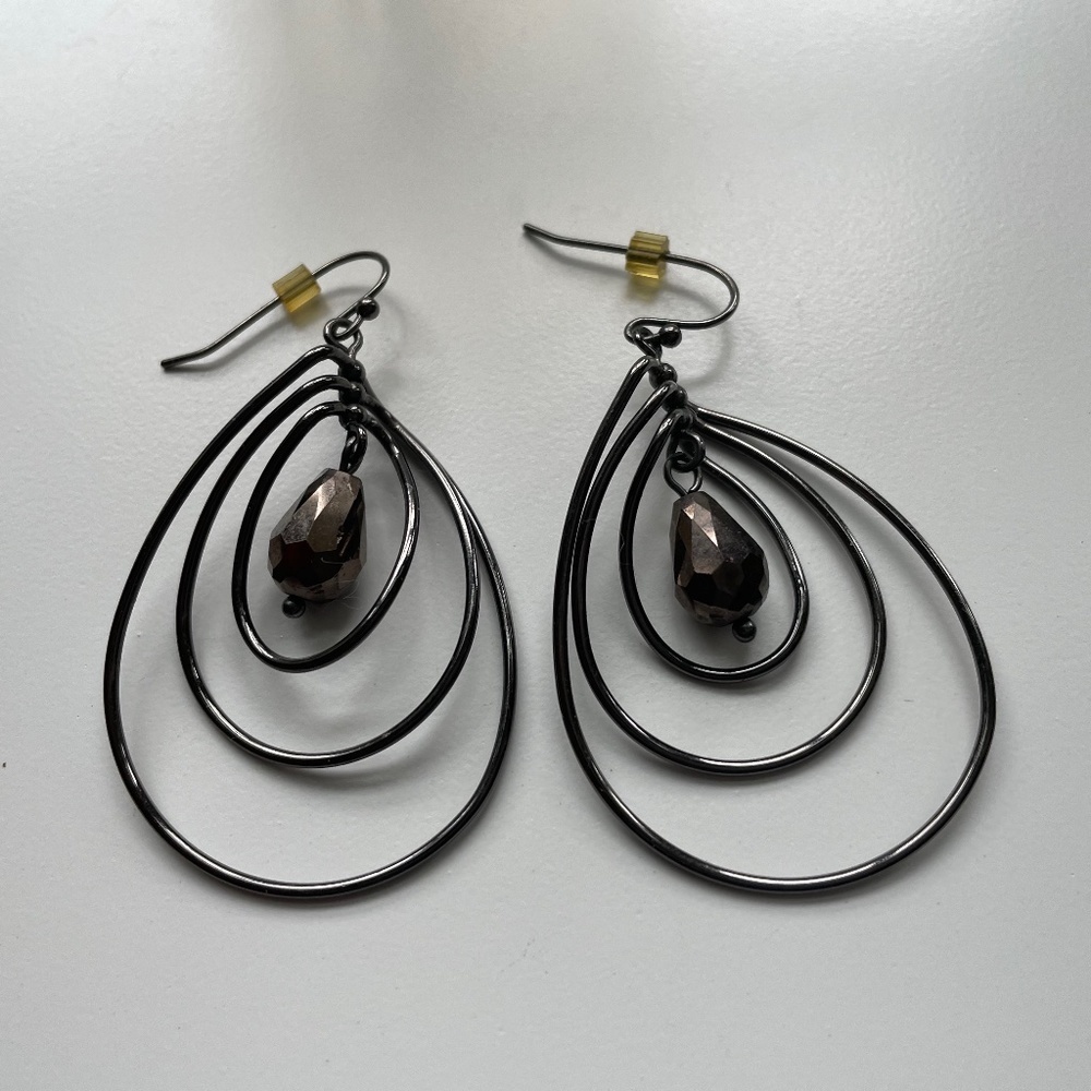 Black wire tri-hoop earring with swinging chocolate brown crystal drop. 2-1/2"